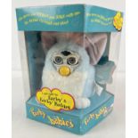 A boxed 1999 Tiger Electronics Furby Babies battery operated toy. In white, pale blue and pink, with