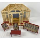 A 1:12 scale dolls house conservatory with 3 piece suite and coffee table. Some panels to roof