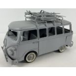 A grey painted modern tin plate model of a VW camper van with ski equipment to roof. Approx. 26 x 16