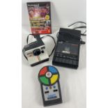 A collection of assorted 1980's electronic toys. An MB Electronics Pocket Simon game; a Polaroid