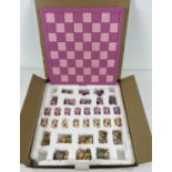 A boxed novelty 'Comic Pig' painted resin chess set.