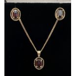 A small 9ct gold oval pendant set with a garnet with rope design to mount on an 18" fine curb chain.
