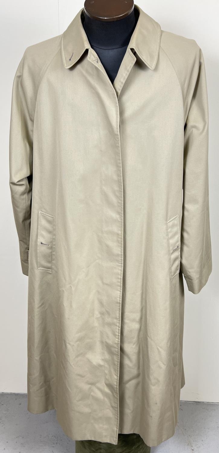 A beige belted long trench coat by Burberrys. Classic check full length lining, button front