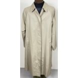 A beige belted long trench coat by Burberrys. Classic check full length lining, button front
