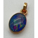 A 9ct gold oval Australian boulder opal set pendant with closed back. Hallmarks to bale. Approx.