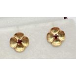 A small pair of vintage 9ct gold flower stud earrings, each set with a small round cut garnet. Posts