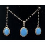 A silver oval shaped pendant necklace & matching drop earrings, set with turquoise blue glass.