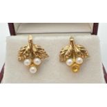 A pair of 9ct gold floral and leaf design stud style earrings each set with small white pearls.