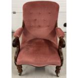 A Victorian mahogany low nursing chair with carved front legs and scroll design arms. With dark pink