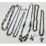 A collection of vintage black bead jewellery. To include iridescent finish bead necklaces with