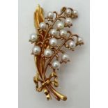 A 9ct gold and pearl brooch in the shape of a Lilley Of The Valley spray of flowers. Pin back with