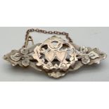 An antique silver and gold sweetheart brooch with pierced work detail and floral & love heart