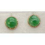 A pair of gold corkscrew post stud earrings each set with a round cabochon of green jade. Complete