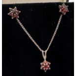 A silver flower shaped pendant on an 18" fine curb chain with matching stud earrings. All set with