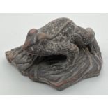 A small carved dark wood figure of a frog. Approx. 2.5cm tall x 4.75cm long.