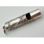 A small silver whistle with scroll and floral decoration and empty cartouche. Silver mark to