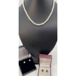 A 16" white freshwater pearl necklace with white metal spring ring clasp. Together with 2 pairs of