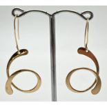 A pair of 14K gold contemporary swirl design drop earrings with hook posts. Marked 14K to both