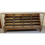 An early 20th century haberdashery shop counter with glass panel front, top & sides. Raised on