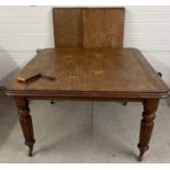 An antique mahogany wind out dining table with turned legs and castor feet. Complete with winding