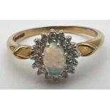 A 9ct gold, opal and diamond dress ring with decorative shoulder detail. Central oval opal