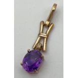 A 9ct gold and amethyst love and kisses design pendant with oval cut stone (approx. 9mm x 7mm).