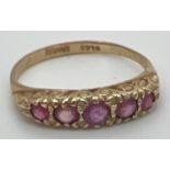 A vintage 9ct and ruby eternity style ring with a scroll design mount. Fully hallmarked inside band.