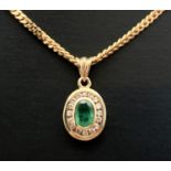 A 9ct gold, emerald and diamond pendant on an 18" 9ct gold curb chain. Oval shaped bezel set emerald
