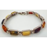 A 7" silver and amber panelled bracelet made from alternating links of green, butterscotch, cognac