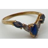 A 9ct gold wishbone ring with 3 marquise cut sapphires and 2 illusion set diamonds. Fully hallmarked