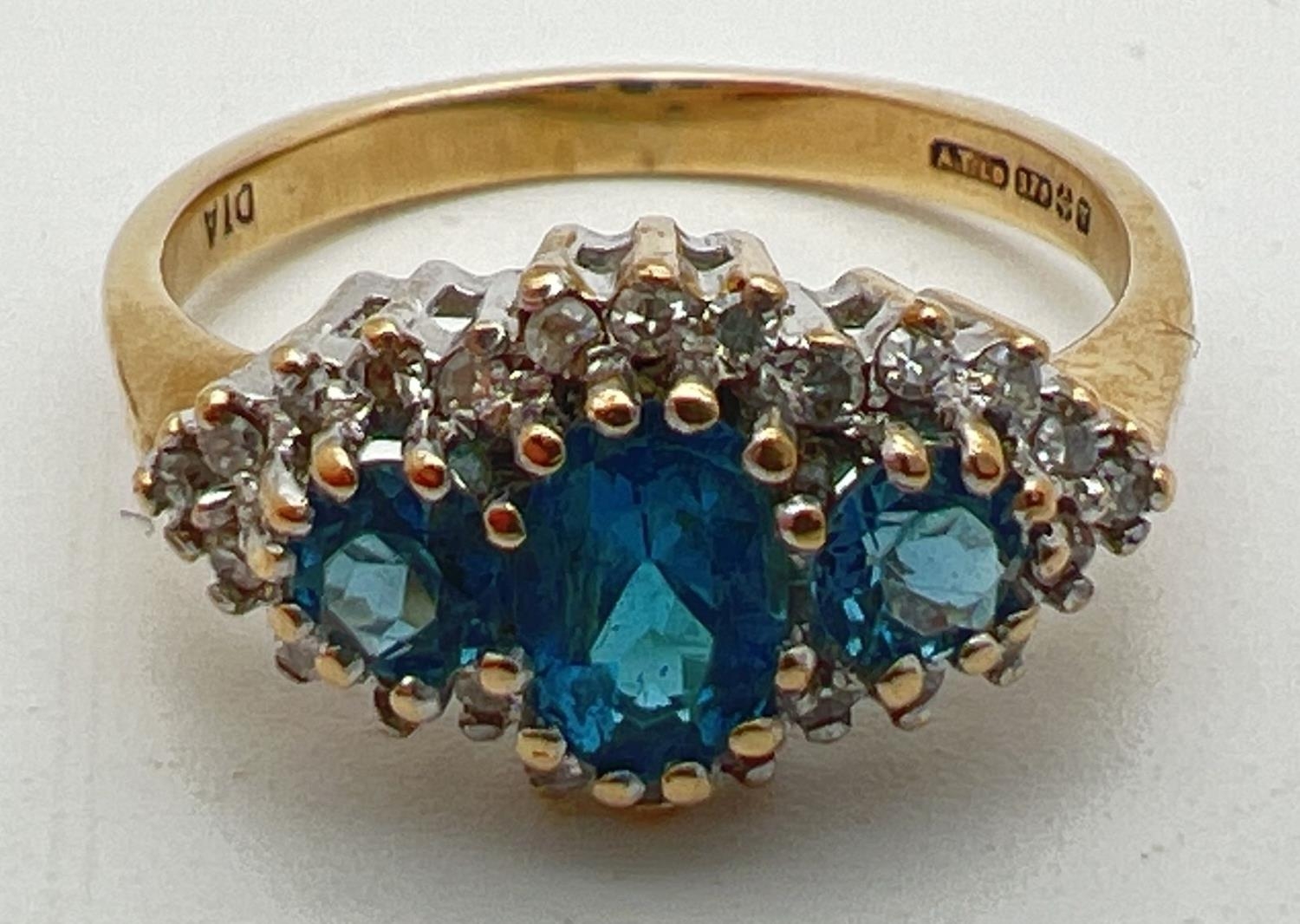 A 9ct gold, London blue topaz and diamond ring in a diamond shaped halo setting. Central oval cut