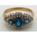 A 9ct gold, London blue topaz and diamond ring in a diamond shaped halo setting. Central oval cut