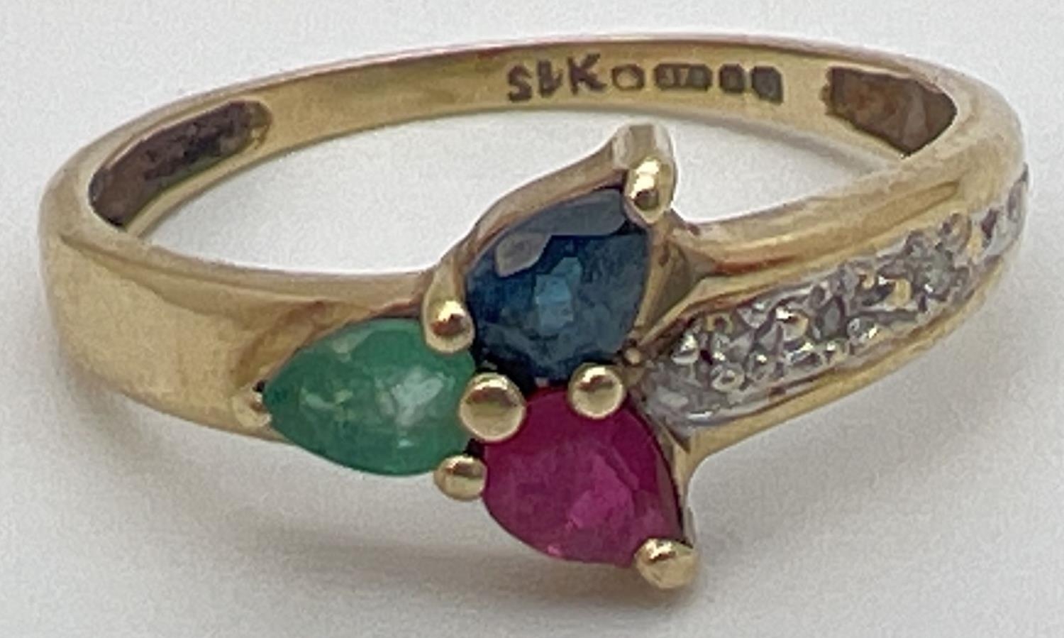 A 9ct yellow gold multi stone trinity ring with a pear cut emerald, sapphire & ruby in a 3 point