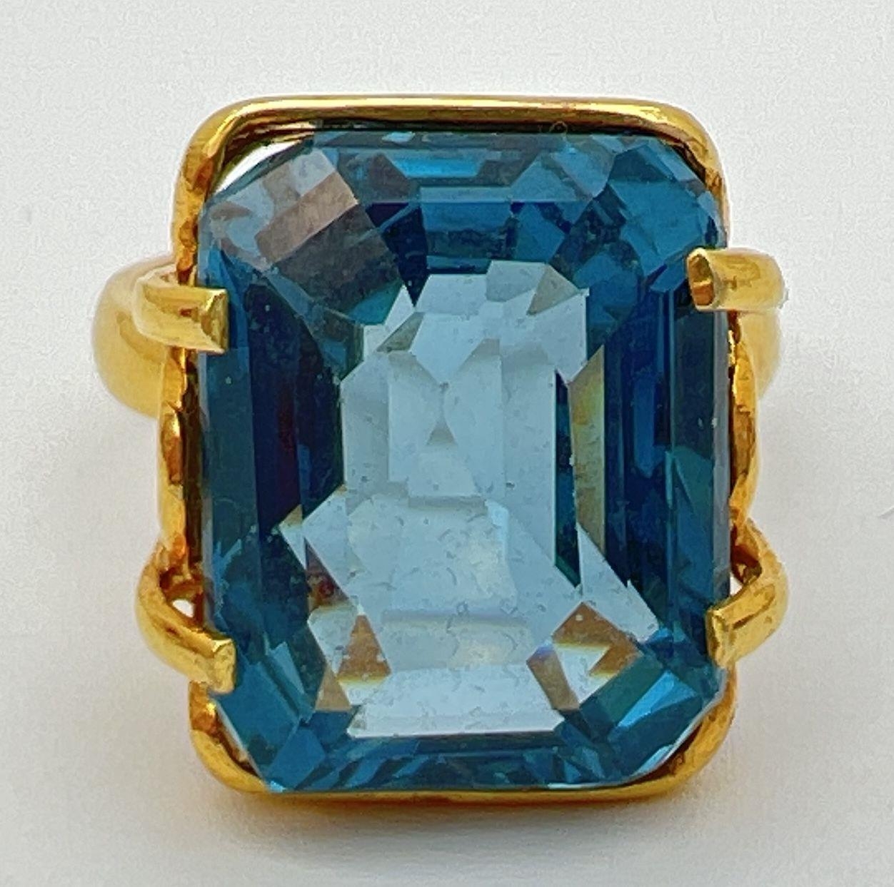 An 18k gold cocktail ring set with a large emerald cut Swiss blue topaz stone. Claw setting with - Image 2 of 4