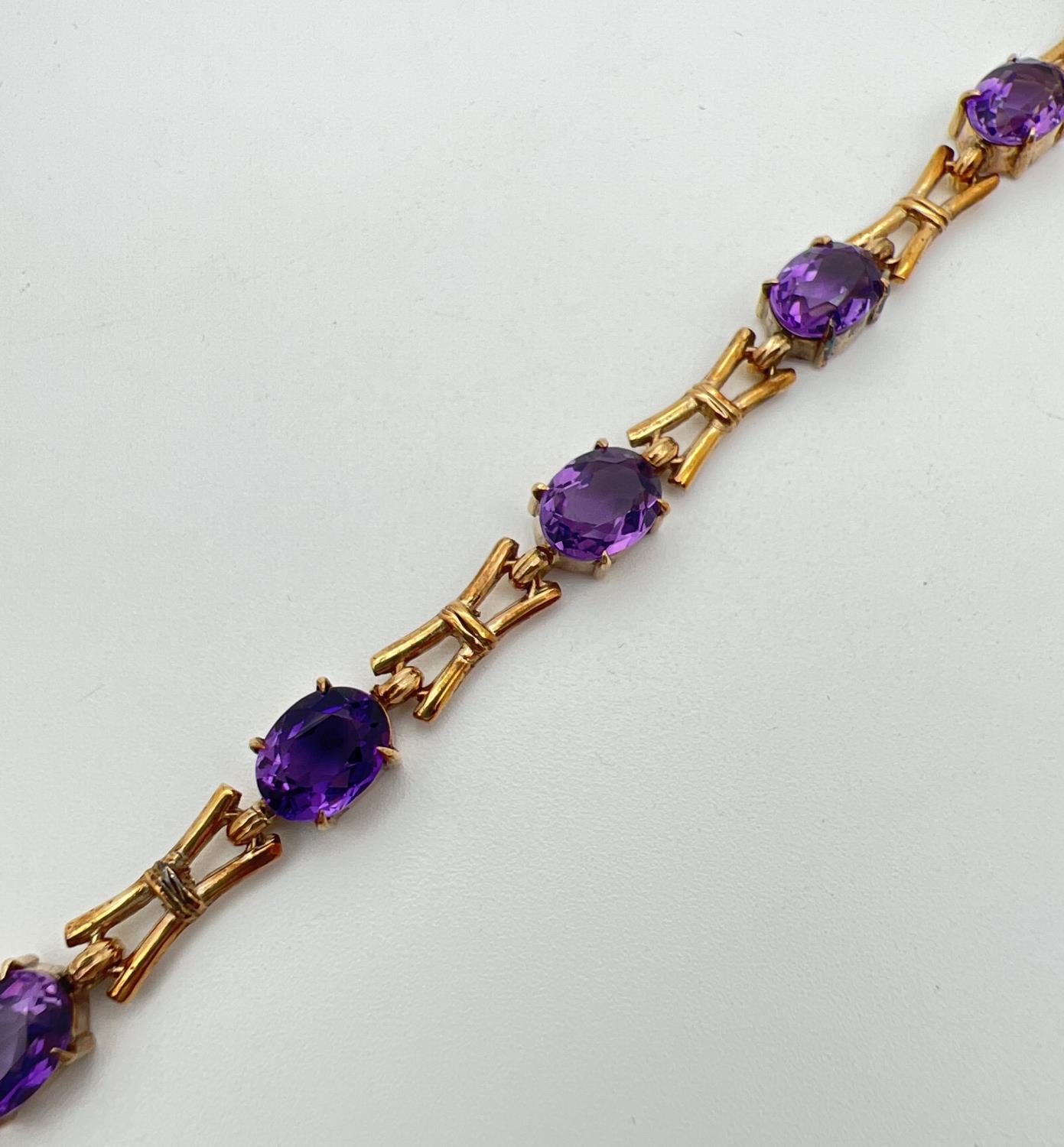 A 9ct yellow gold and amethyst love and kisses style 13 link bracelet of alternating oval cut