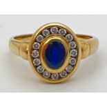 An 18ct gold, sapphire and diamond ring with central oval shaped bezel set sapphire (approx. 6mm x