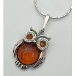 A 925 silver and amber pendant in the shape of an owl on a 17" rectangular link silver chain.