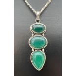 A large green 3 stone pendant in a white metal mount, on an 18" curb chain. Lobster claw clasp and