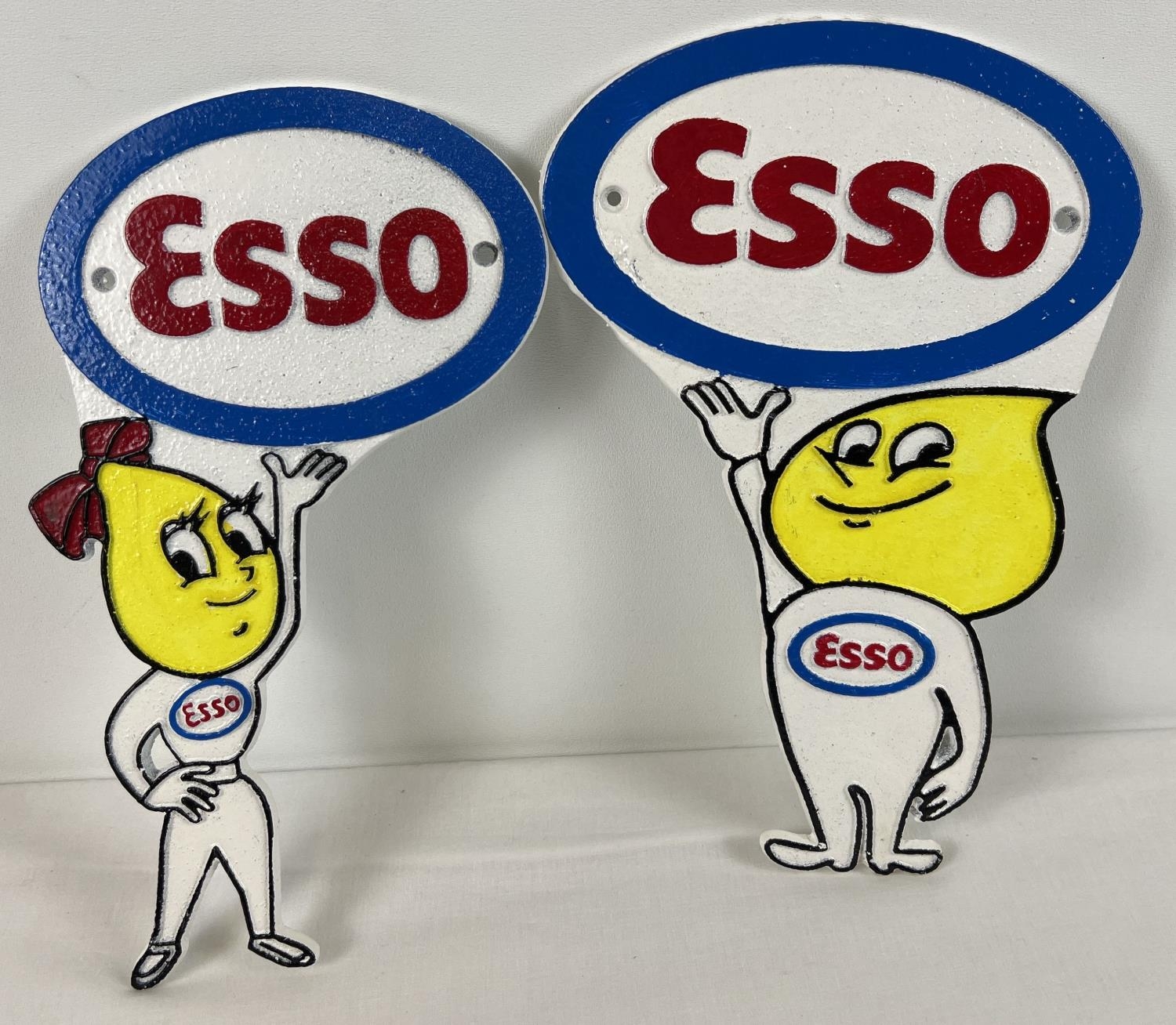 A pair of Esso painted cast iron wall plaques depicting the oil drop boy and girl mascots. With