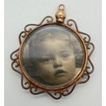 A vintage 9ct gold double sided circular photo pendant with decorative scroll detail to edges.