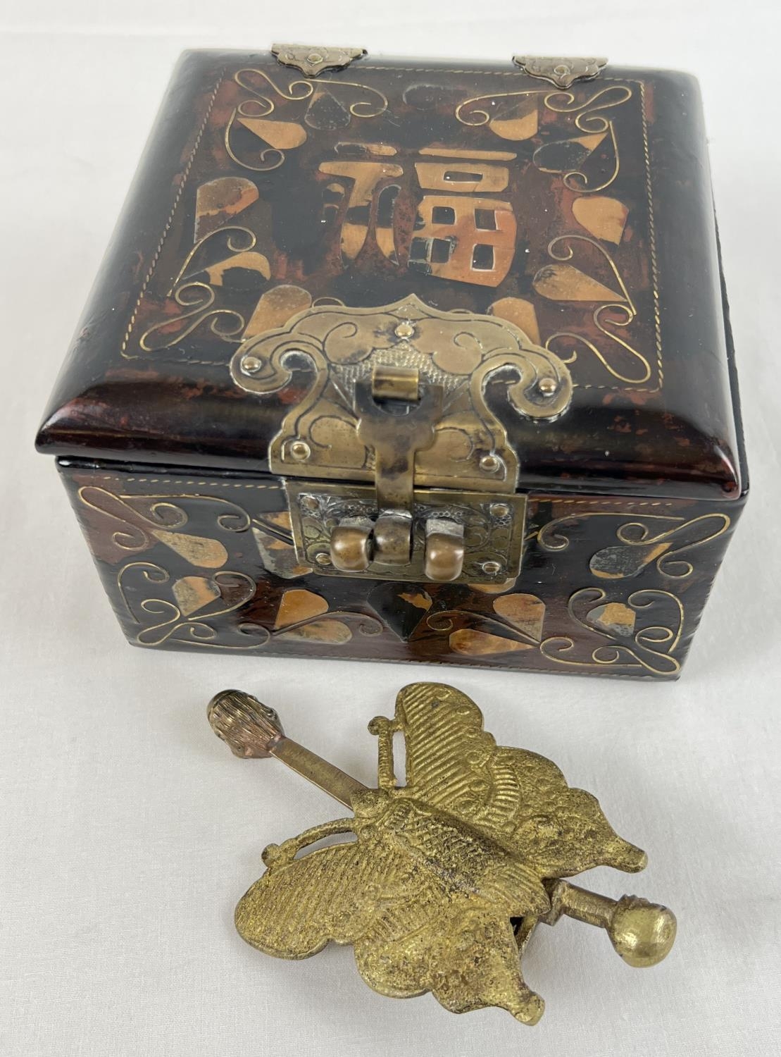 A vintage Chinese lacquer box with complete with decorative brass butterfly shaped box lock. Box