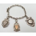 A vintage sterling silver charm bracelet with t bar style clasp and 3 silver shield medallions.
