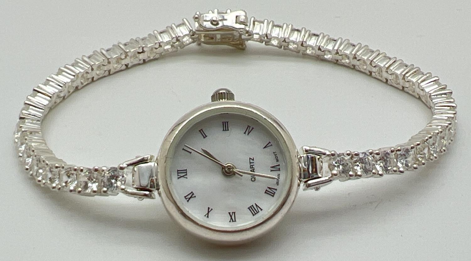 A modern silver cased ladies quartz wristwatch with mother of pearl face and clear stone set