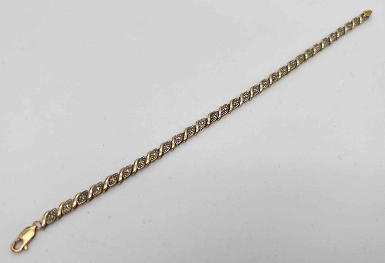 A 7.5 inch 9ct gold and diamond decorative bracelet. 30 small wave design panels, 15 set with a - Image 2 of 3