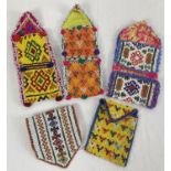 5 Central Asian heavily beaded wrap pouches, in varying colours, sizes and designs.