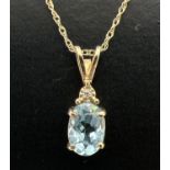 A 9ct gold blue topaz and diamond set drop pendant on an 18" fine Singapore style chain with