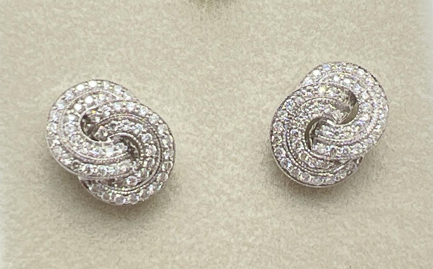 A pair of 18ct white gold Art Deco style twist knot design diamond earrings by Luke Stockley,