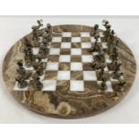 A vintage circular shaped marble chess board with cast metal Greek Mythology chess pieces (2 a/f).