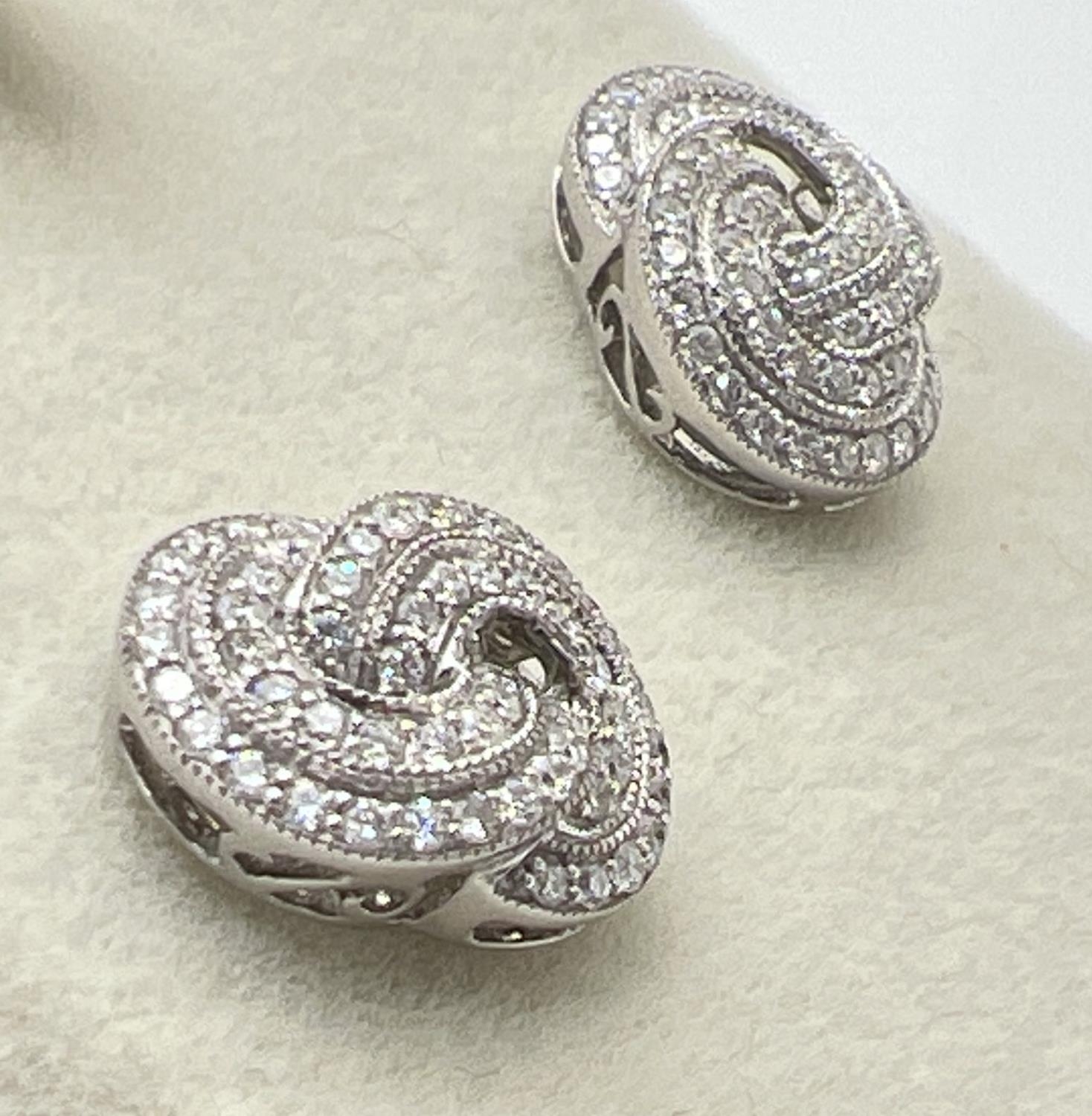 A pair of 18ct white gold Art Deco style twist knot design diamond earrings by Luke Stockley, - Image 2 of 3