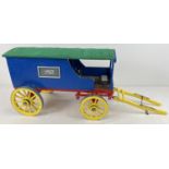 A painted wooden model caravan of Harveys Stores with green fabric roof. Together with metal